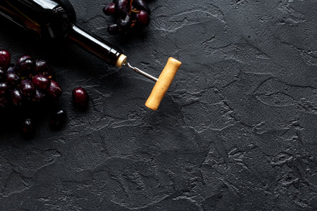 Red wine bottle with corkscrew and grape. Top view