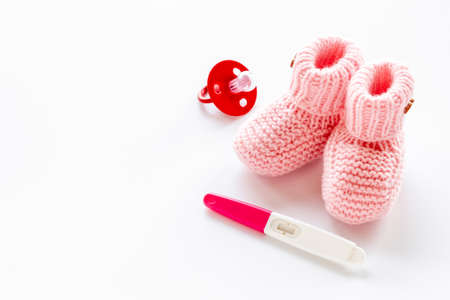 Pink baby girl booties with pregnancy test. Motherhood and pregnancy conceptの写真素材