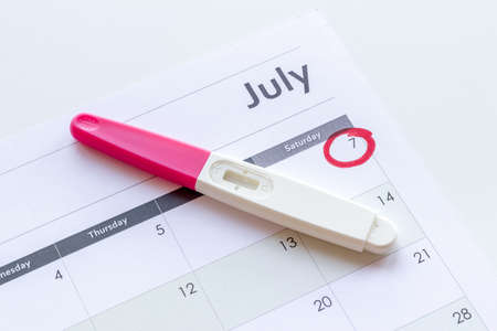 Calendar with pregnancy test, top view. Motherhood and pregnancy conceptの写真素材