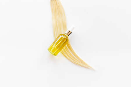 Essential oil for hair care with blond hair curlの写真素材