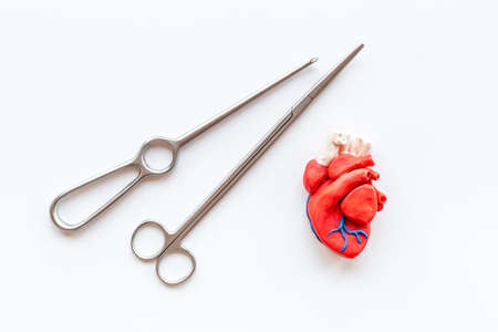 Heart surgery concept with surgical instruments and heart model made of plastilineの写真素材