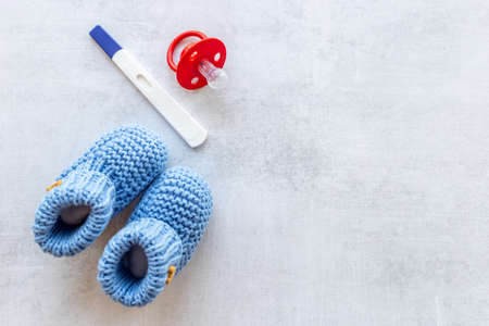 Pregnancy test and blue baby boy booties. Motherhood and pregnancy conceptの写真素材