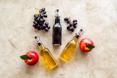 Apple cider and balsamic vinegar in bottles with grapes and red applesの写真素材