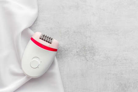 White epilator on soft silk. Hair removal and depilatory conceptの写真素材