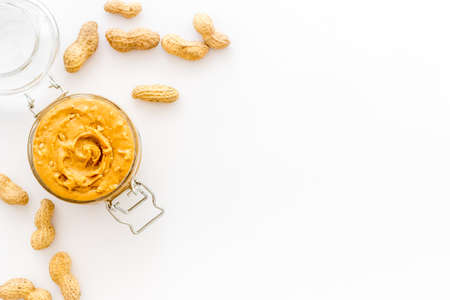 Creamy peanut butter in glass jar with nuts, top viewの写真素材