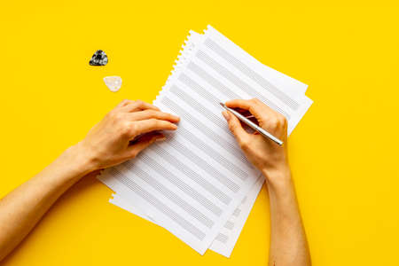 Music sheets with hands writing notes. Compose music conceptの写真素材