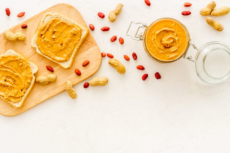 Peanut butter sandwiches and creamy butter in glass jar, top viewの写真素材