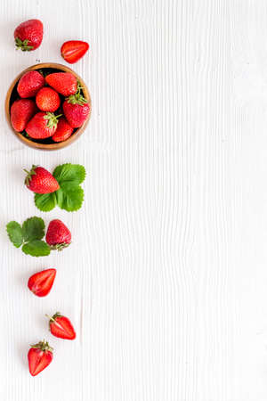 Bowl of ripe strawberry with leaves. Berry flay lay, top viewの写真素材