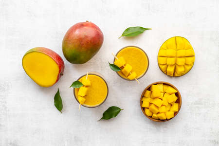 Top view of mango slices and cubes with fresh mango smoothieの写真素材