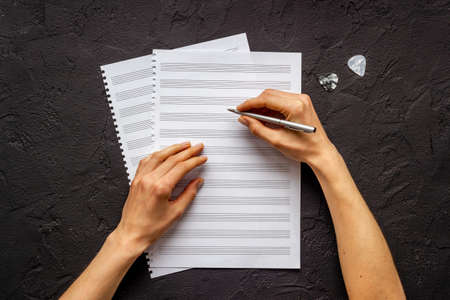 Music sheets with hands writing notes. Compose music conceptの写真素材