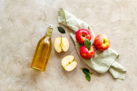 Apple cider vinegar in glass bottle with fresh red applesの写真素材