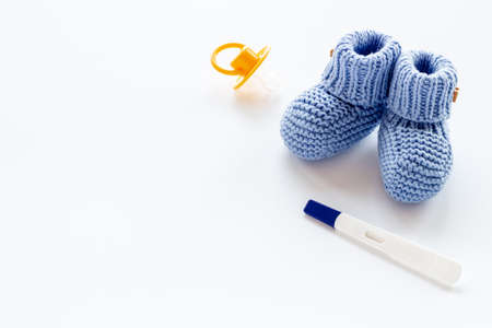 Baby boy booties with pregnancy test. Morherhood and pregnancy conceptの写真素材