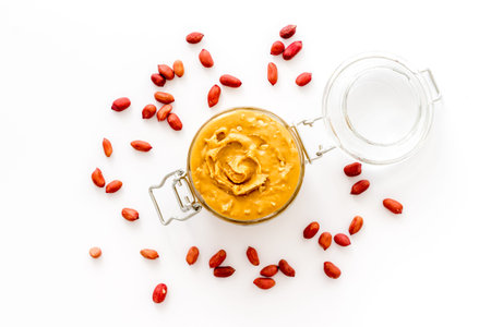 Bowl of peanut butter with nuts on kitchen table. Overhead viewの写真素材
