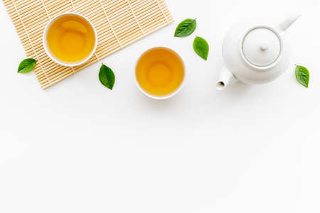 White teapot and cups of black tea with leaves, top viewの写真素材