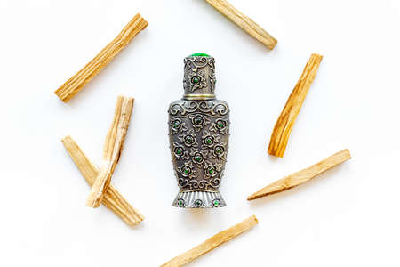 Agar wood tree oil perfume in silver bottle with sticks of treeの写真素材