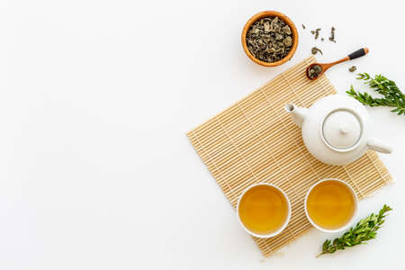 Asian food and drink set white teapot and black tea in two cupsの写真素材