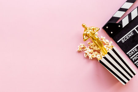 Movie clapper board with golden film award statue and popcornの写真素材