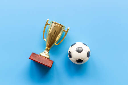 Sport champion award - golden trophy cup with game ball, top viewの写真素材