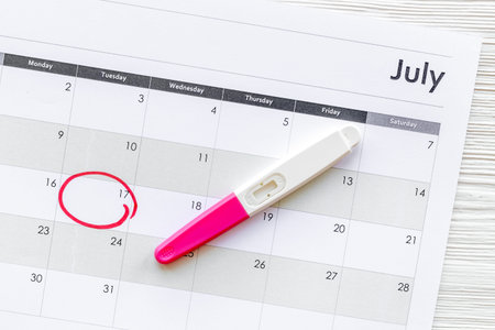 Pregnancy test on calendar. Pregnancy and female health care concept