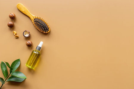 Macadamia oil for hair care with wooden hair brush. Top view