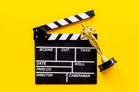 Movie clapper board with golden film award statueの写真素材