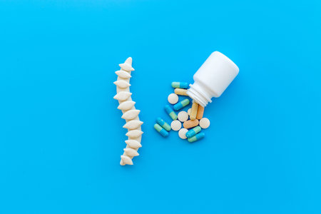 Anatomical spine skeleton with medical pills. Spinal diseases treatment concept