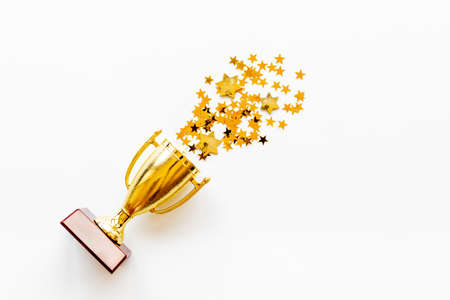 Victory concept with winner golden trophy cup and shiny starsの写真素材