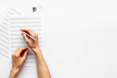 Music sheets with hands writing notes. Compose music conceptの写真素材