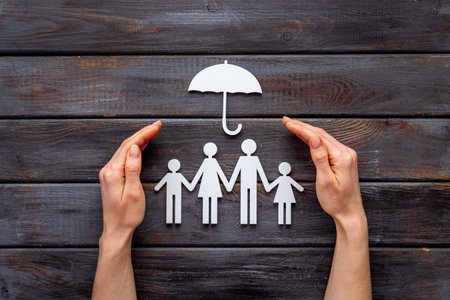 Hands hold family figure. Health insurance concept. Top view