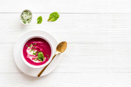 Red vegetarian beet soup in white bowl with sour creamの写真素材