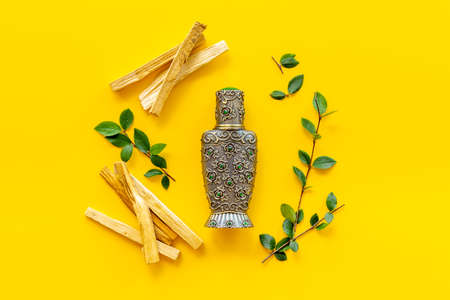 Agar wood tree oil perfume in silver bottle with sticks of treeの写真素材
