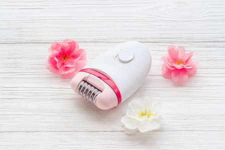 Epilator with pink and white flowers. Hair removal and depilatory concept