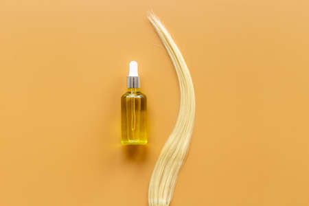 Essential oil for hair care with blond hair curlの写真素材