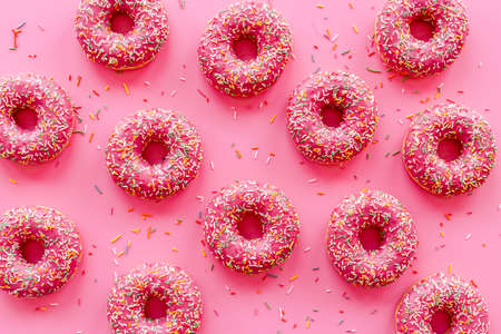 Pink donuts with sprinkles set, top view. Sweet bakery backgroundの写真素材