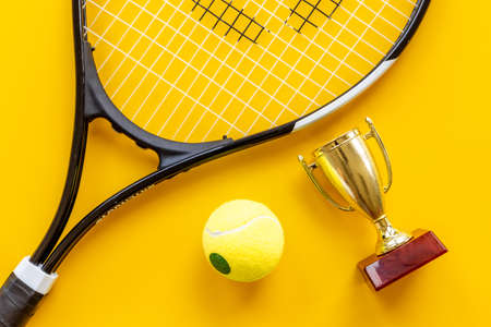 Tennis champion award - small golden trophy cup with tennis racket and ballの写真素材