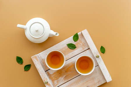 Asian food and drink background white teapot and black tea in two cupsの写真素材