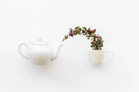 Tea concept with white teapot and dry tea leavesの写真素材