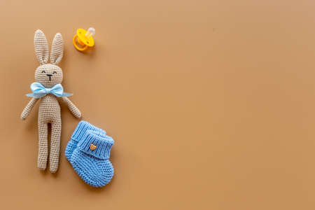 Kids toy knitted rabbit with baby booties shoes, top view