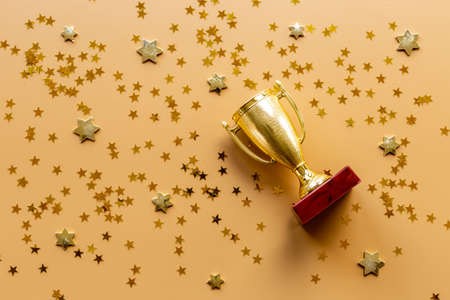 Victory concept with winner golden trophy cup and shiny starsの写真素材