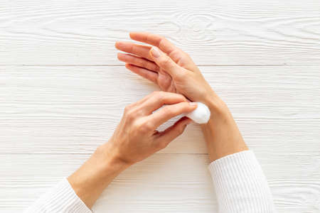 Cotton wool balls in female hands - clean and care for skinの写真素材