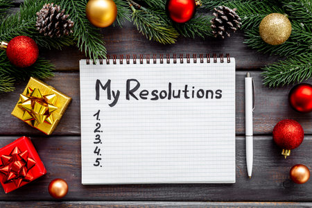 Resolutions of the year - New Year plan, text in notebook. Top view, flat lay