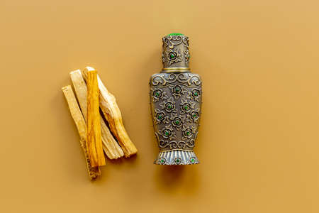 Agar wood tree oil perfume in silver bottle with sticks of treeの写真素材