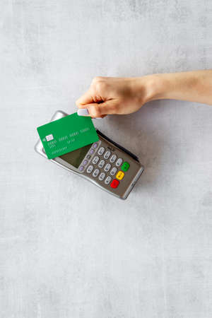 Hand with credit card on pos payment terminal. Top viewの写真素材