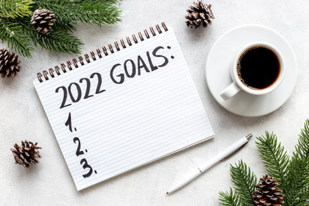 New year goals and resolutions concept. Hand writing text on notebook, top view