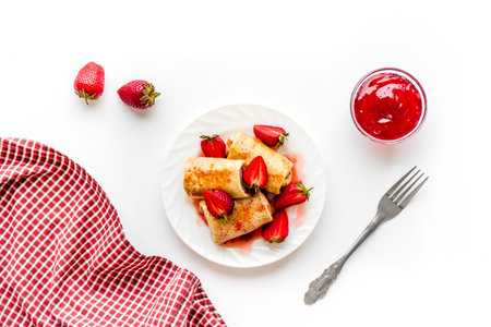 Hot rolled pancakes with strawberry and berry sauce