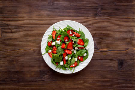 Spinach salad with strawberry and goat cheese, top viewの写真素材
