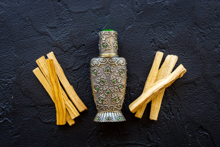 Arabic oud oil perfume in silver bottle with crystals and sticks of treeの写真素材