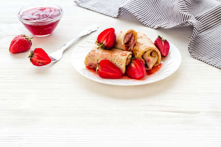 Sweet breakfast - rolled pancakes with strawberry and berry sauceの写真素材