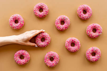 Pattern of pink glazed donutes with sprinkles, top viewの写真素材