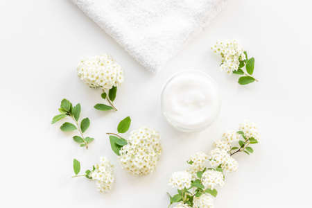 White blossoms flowers with skin cream in glass jarの写真素材
